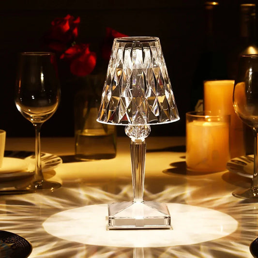 Lámpara de cristal LED recargable, elegante y sencilla, iluminando una mesa.